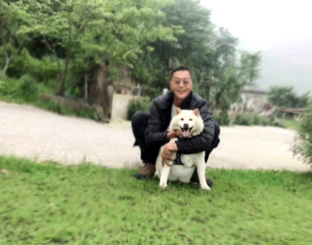 An embrace of love – Hoon hugs dog Shiba Ken from behind in a tender moment.