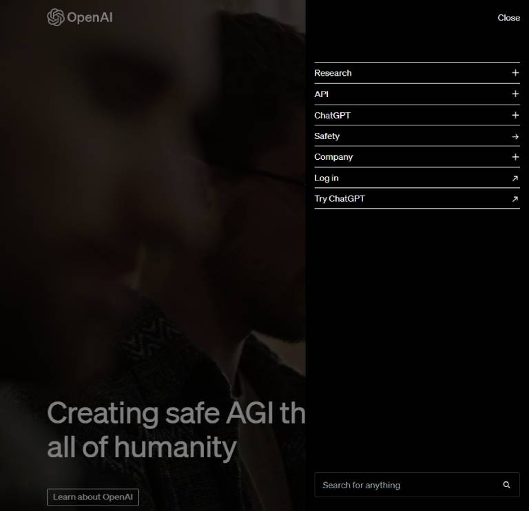 A screenshot of OpenAI's website menu with an obscured background featuring a close-up of a person, and a prominent message that reads "Creating safe AGI that benefits all of humanity".